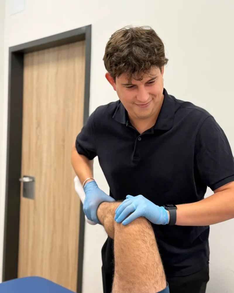Juan Miguel Rodríguez Pérez, fisioterapeuta, valorando la rodilla de un paciente